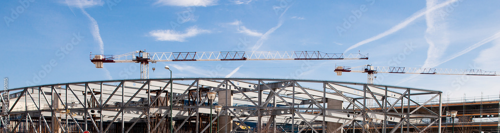 Obraz premium Iron structure and construction crane with blue sky and clouds