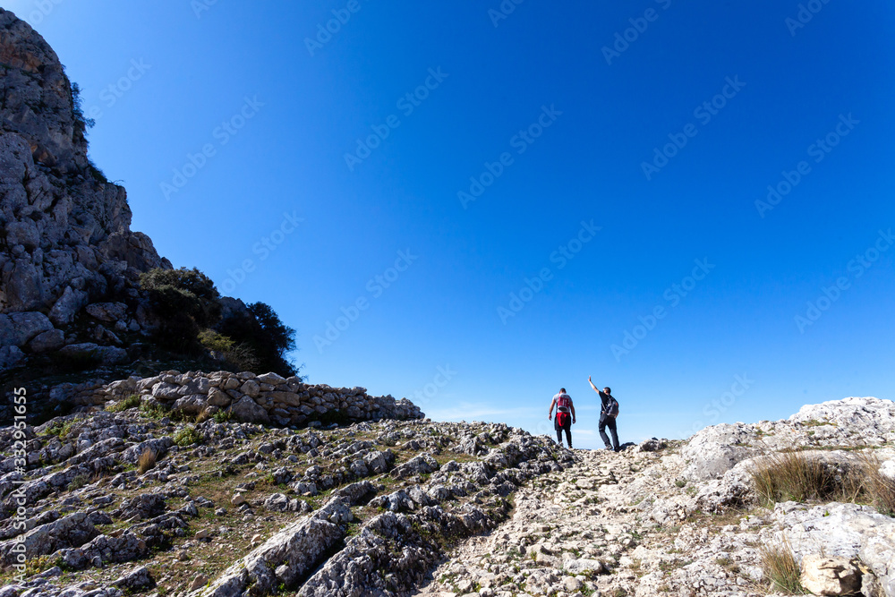 Hiker couple going up very stony ground.