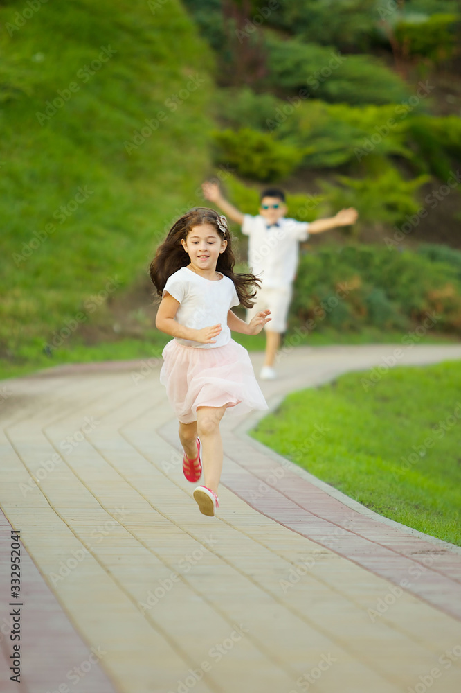 A girl and a boy run along the path and play catch-up.