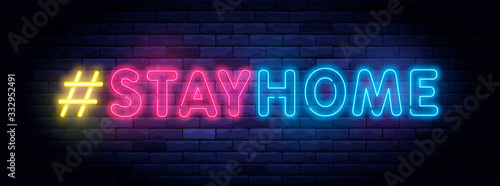 Stay home hashtag in neon style. Coronavirus pandemic protection and prevention effort. Social activity message. Self-isolation and quarantine. To stay at home brightly illuminated neon sign on wall.