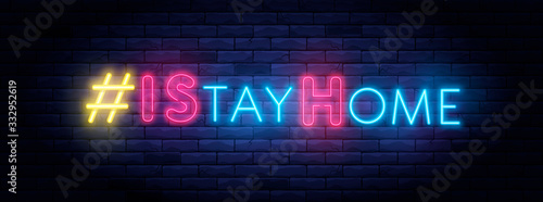 I Stay home hashtag in neon style. Coronavirus pandemic protection and prevention effort. Social activity message. Self-isolation and quarantine. To stay at home brightly illuminated neon sign on wall