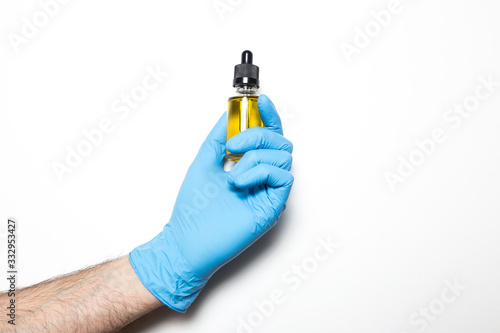 Male hand in a medical glove with a vaccine on a white background.