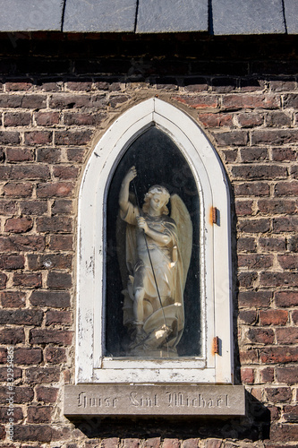 Gent, Belgium - March 22, 2020: Saint Michael statue found in a wall in the Saint Elisabeth beguinage. Unesco listed.