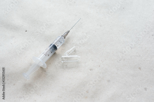 Syringe for injection and ampoule on a paper background. The concept of medicine, healthcare. Flat lay, copy space