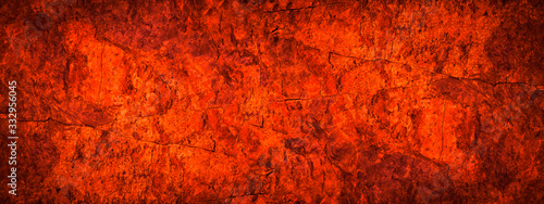 Red orange grunge background. Toned rock texture. Close-up. Bright fiery red banner with copy space. Color trend 2020.
