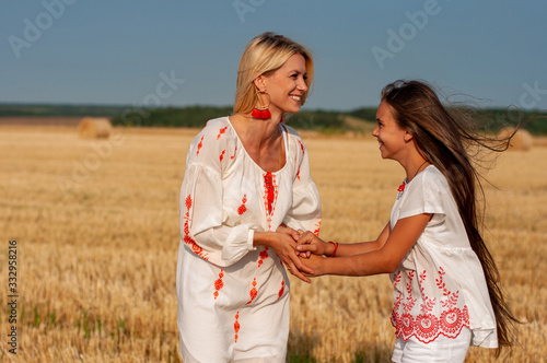 Konstfotografi horizontal portrait of two happy lovely sisters in embroidered shirts who laugh