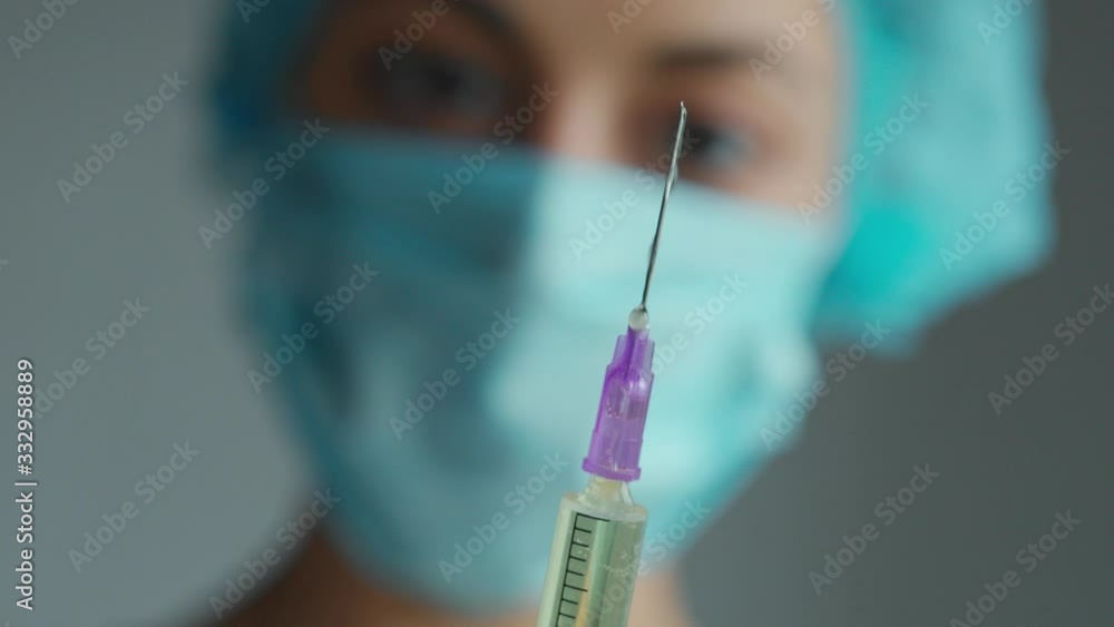 Syringe, vaccine, medical injection. Syringe needle with liquid medicament closeup. Woman doctor blurred on background. concept of vaccination, injection, medicine. Syringe, vaccine, medical injection. Syringe needle with liquid medicament closeup. Woman doctor blurred on background. concept of vaccination, injection, medicine.