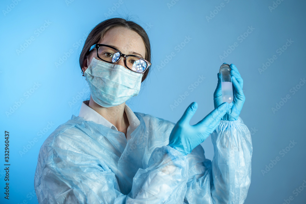 Doctor scientist holds a test vial with a vaccine against the virus developed in the blue laboratory Doctor scientist holds a test vial with a vaccine against the virus developed in the blue laboratory