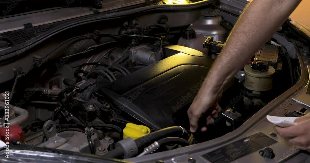 Removing the oil dipstick to check the level, preventive maintenance on the car