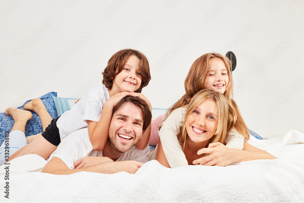 Glückliche Familie mit zwei Kindern im Bett Glückliche Familie mit zwei Kindern im Bett