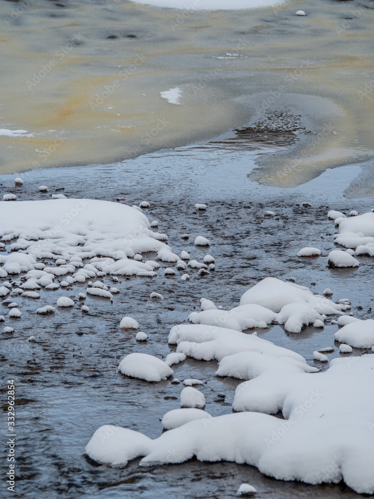 winter Creek flows between rocks ice and snow winter Creek flows between rocks ice and snow