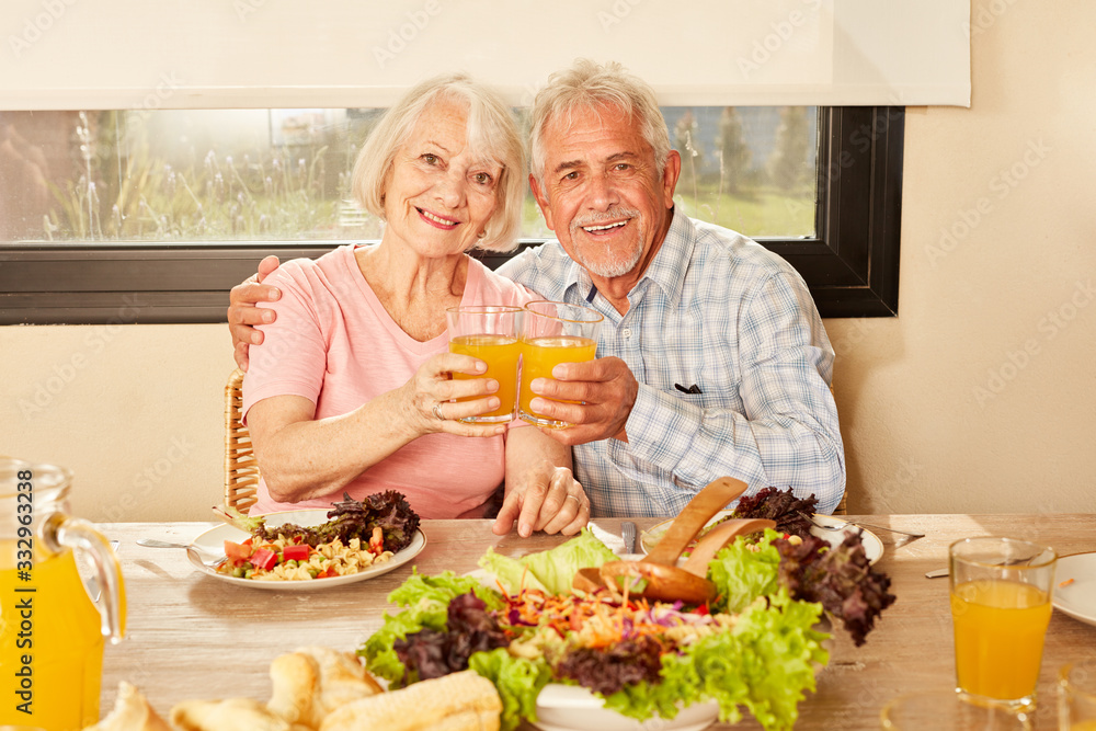 Paar Senioren beim Anstoßen mit Orangensaft