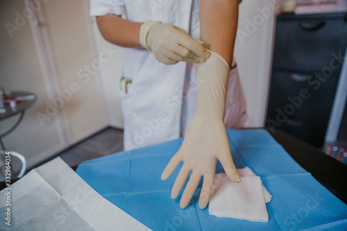 Hands medical glove prepare for operation. Female doctor wearing protective gloves  hands close up. coronavirus