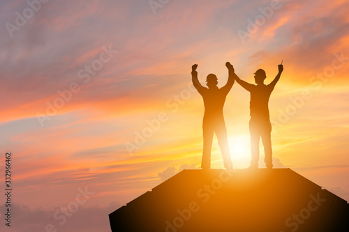 Silhouette of Business engineer man with clipping path celebration success happiness on container box evening sky sunset background, Teamwork Concept