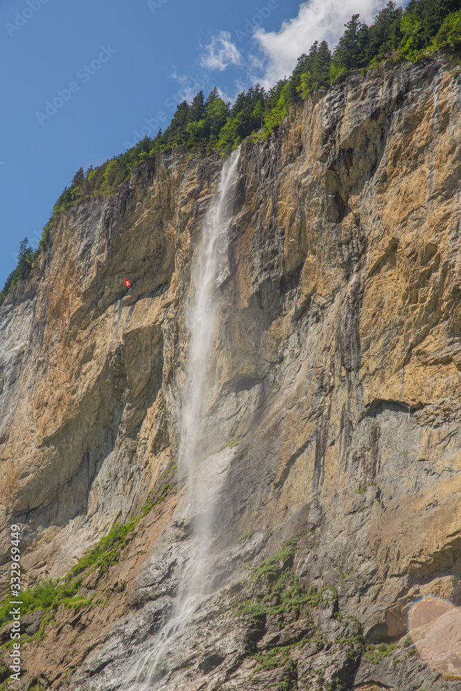 Tall waterfall from rocky cliff, Lauterbrunnen, Swiss Alps, vertical