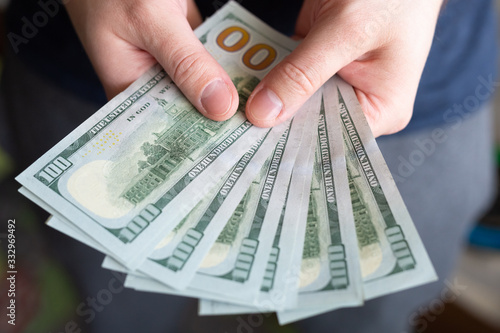 Dollars in man's hands. Profits, savings. Success, motivation, financial flows, wealth. Stack of dollars. 100 us dollars