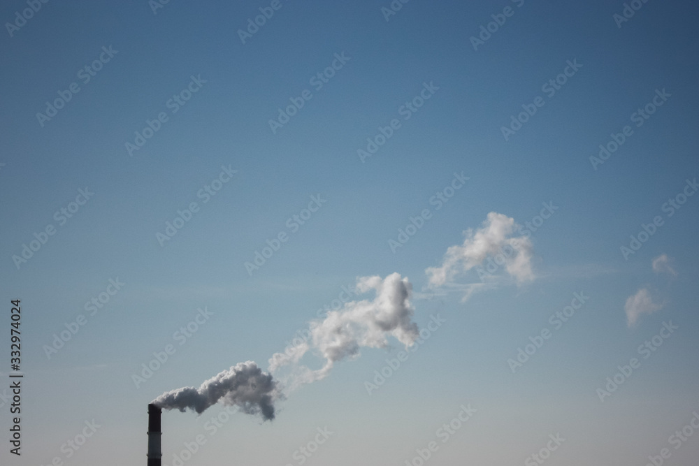 steam smoke coming from a chimney in an industrial zone on the outskirts of a city steam smoke coming from a chimney in an industrial zone on the outskirts of a city