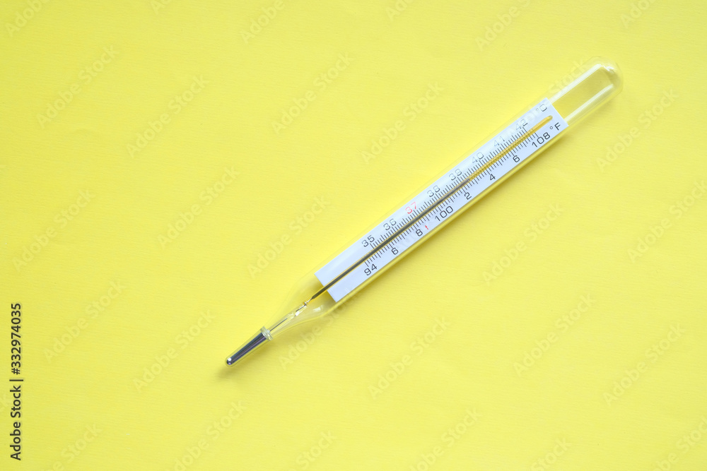 top view of thermometer on yellow background top view of thermometer on yellow background