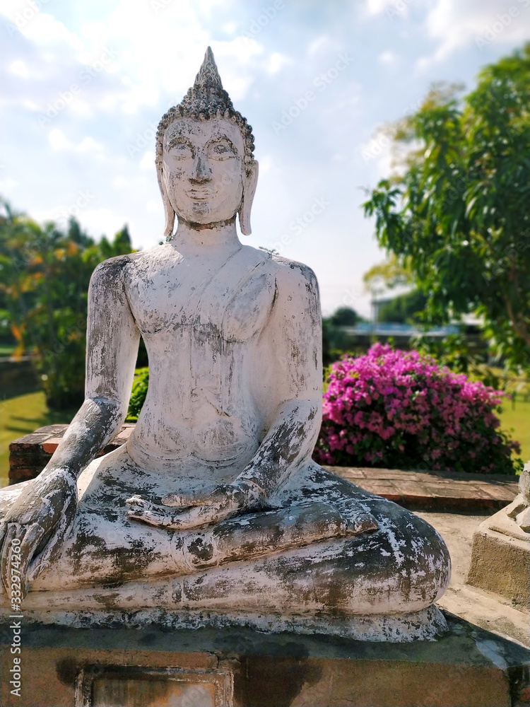 Obraz premium White stone Buddha statue and blue sky background at Wat Yai Chaya Mongol in Ayutthaya, Thailand. Beautiful Buddha statue in Asia.