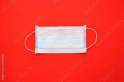 disposable medical mask on a red background.