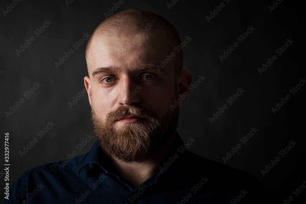 a mysterious portrait of a man with a beard on a black background with a small amount of light