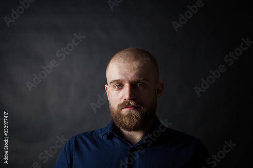 a mysterious portrait of a man with a beard on a black background with a small amount of light © KseniyaK
