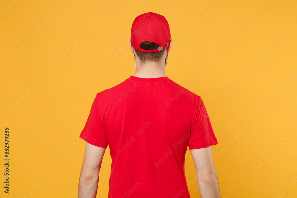 Back rear view delivery man in red cap blank t-shirt print uniform isolated on yellow background studio Guy employee working courier Service quarantine pandemic coronavirus virus 2019-ncov concept.