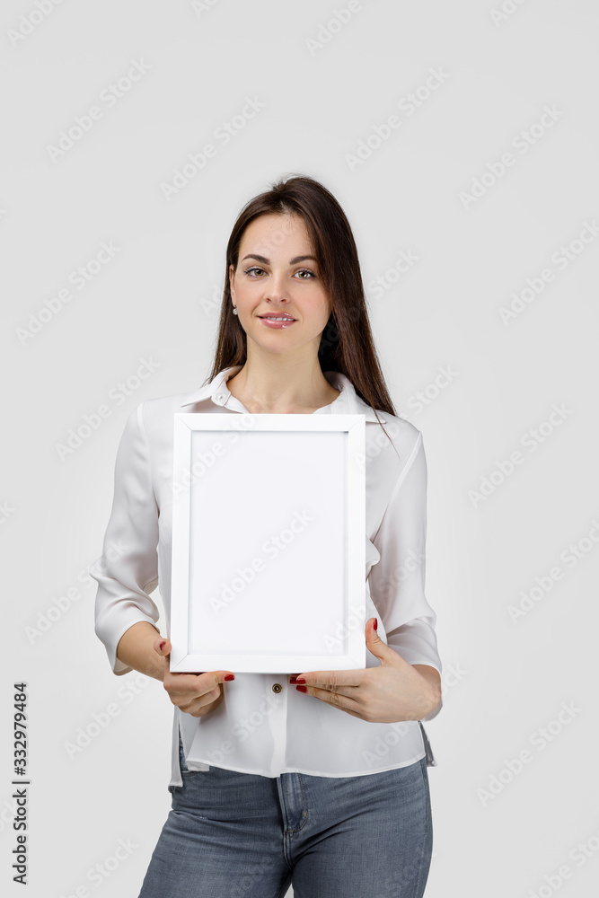 Beautiful smiling woman holding blank board for text on gray background. girl with empty frame for your text Beautiful smiling woman holding blank board for text on gray background. girl with empty frame for your text