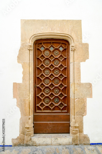 Old entrance door of an ancient building with a graceful pattern in Sitges, Spain