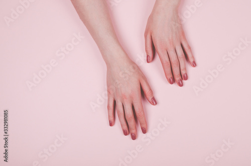 Woman hands with manicure on light pink background