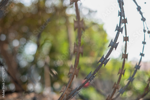 Close-up fence with barbed wire against a blurred background