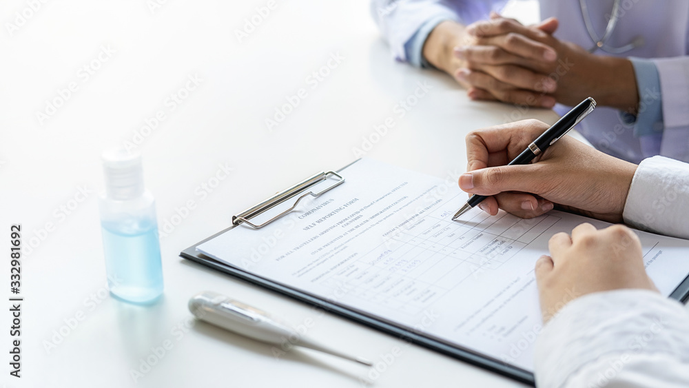 Asian woman filling a coronavirus self reporting form with a doctor recommended at hospital. Medical and Health concept. Asian woman filling a coronavirus self reporting form with a doctor recommended at hospital. Medical and Health concept.