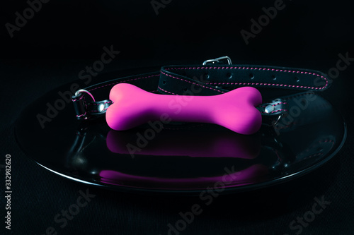 Obraz na płótnie Pink gag bone adult toy on black plate