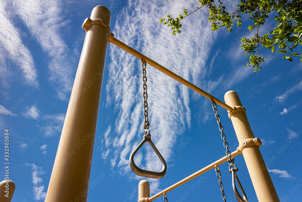 Gymnastics rings at park on sunny day with blue sky Gymnastics rings at park on sunny day with blue sky
