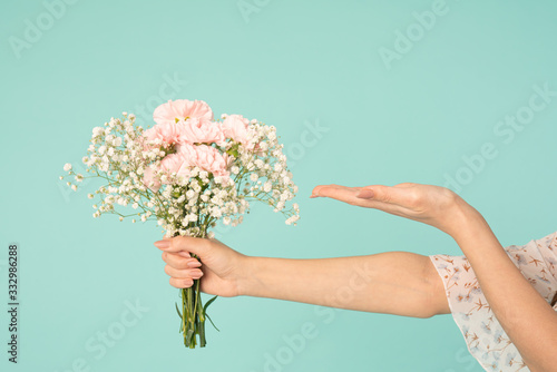 Girls hand holding spring bouquet, other hand with open palm holds your product