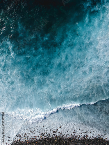 Leinwand Poster Aerial drone view of spashing waves in blue ocean