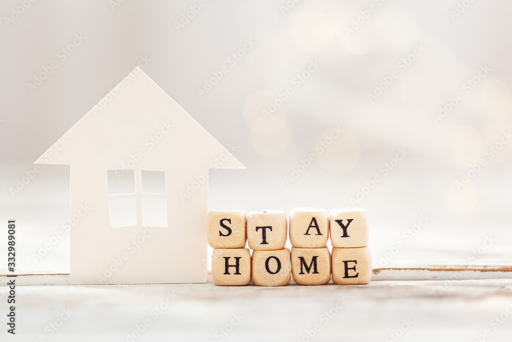 Words stay at home made of wooden blocks and White paper house , social distancing, concept staying at home during emergency - obrazy, fototapety, plakaty 