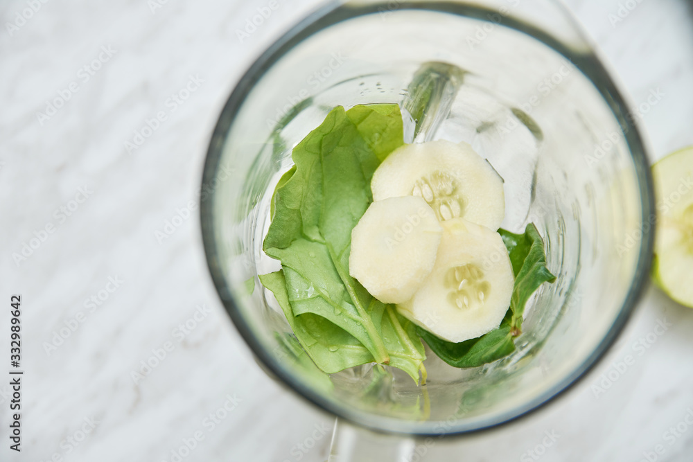 A top view of a blender with cucumber and spinach A top view of a blender with cucumber and spinach