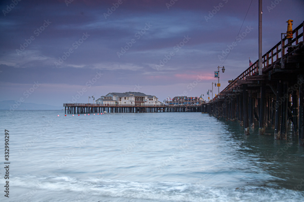 beautiful sunset clouds over a pier on the California coast