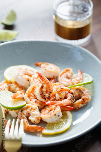 Fried tiger shrimp with lime, lemon and spices on a ceramic dish. Healthy dinner or lunch concept.