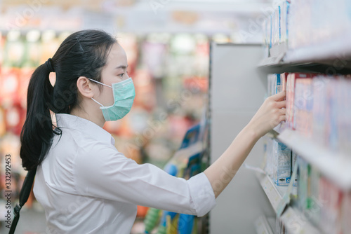 Asian women and surgical mask shopping some food in supermarket, covid-19 crisis