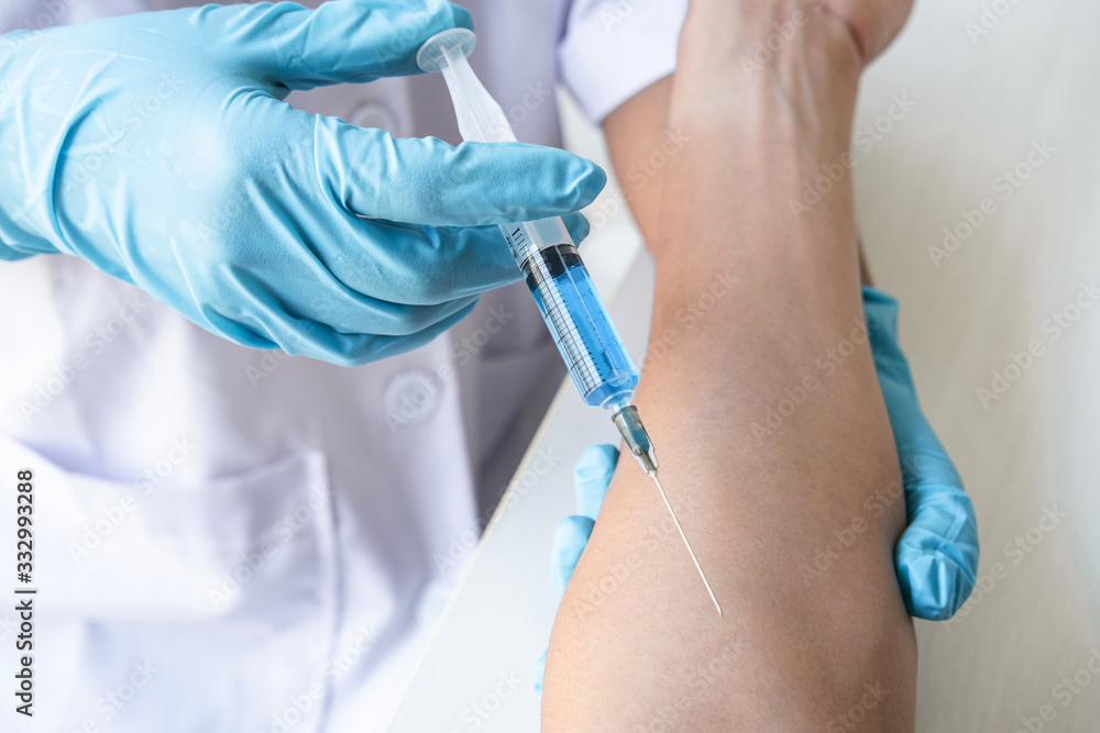 Doctor making injection vaccination patient to prevent pandemic of the disease, flu or influenza virus in clinic Doctor making injection vaccination patient to prevent pandemic of the disease, flu or influenza virus in clinic