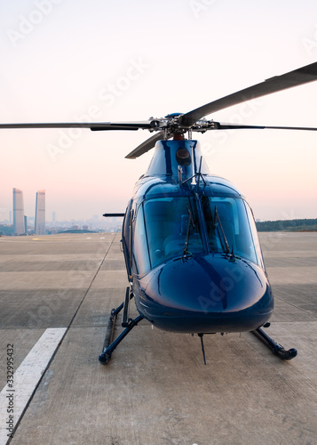 beautiful blue helicopter stands on the helipad and is preparing to fly over the metropolis photo