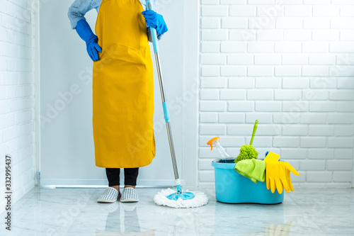 Tableau sur toile Housekeeping and cleaning concept, Happy young woman in blue rubber gloves wipin
