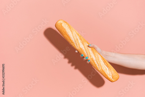 Hand holding a baguette. photo