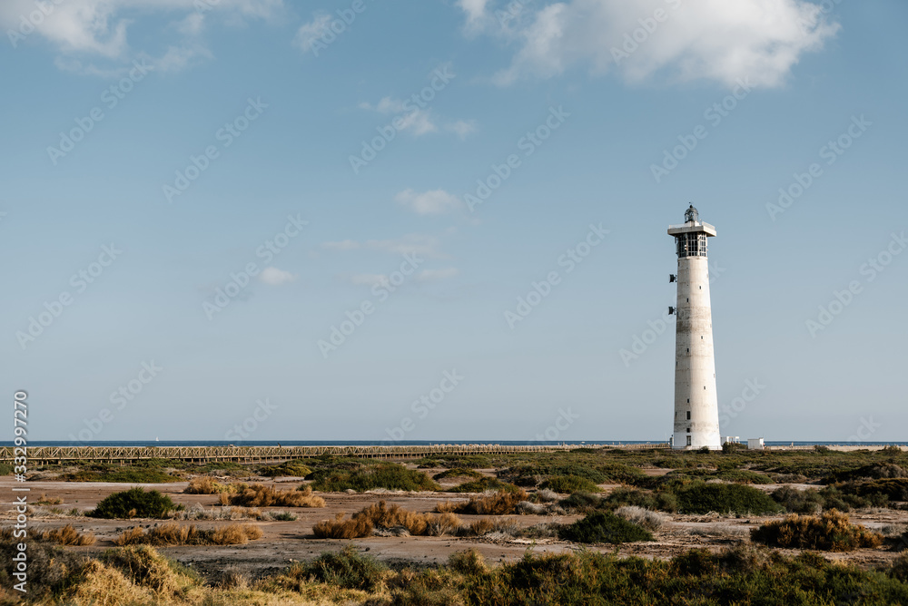 High white lighthouse on ocean shore. High white lighthouse on ocean shore.