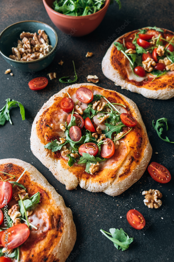 Pizza with arugula, walnuts and cherry tomatoes Pizza with arugula, walnuts and cherry tomatoes