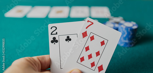 Fotografie Bad poker gamble or unlucky hand concept with player going all in with 2 and 7 (