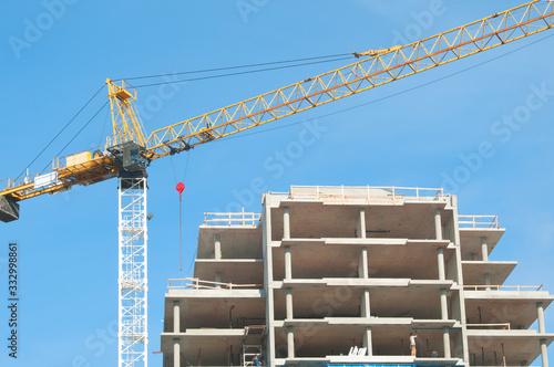 Concrete Highrise Construction site, with Tower Crane, blue sky background