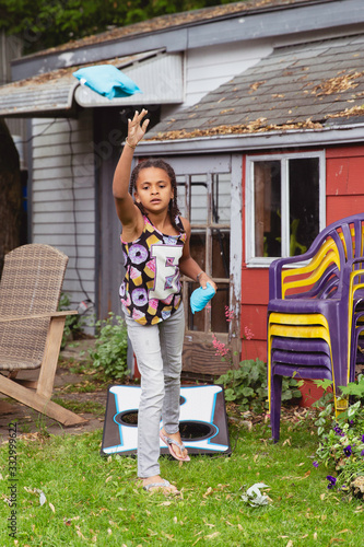 Pretty child throwing beanbags for the game cornhole or sacktoss photo